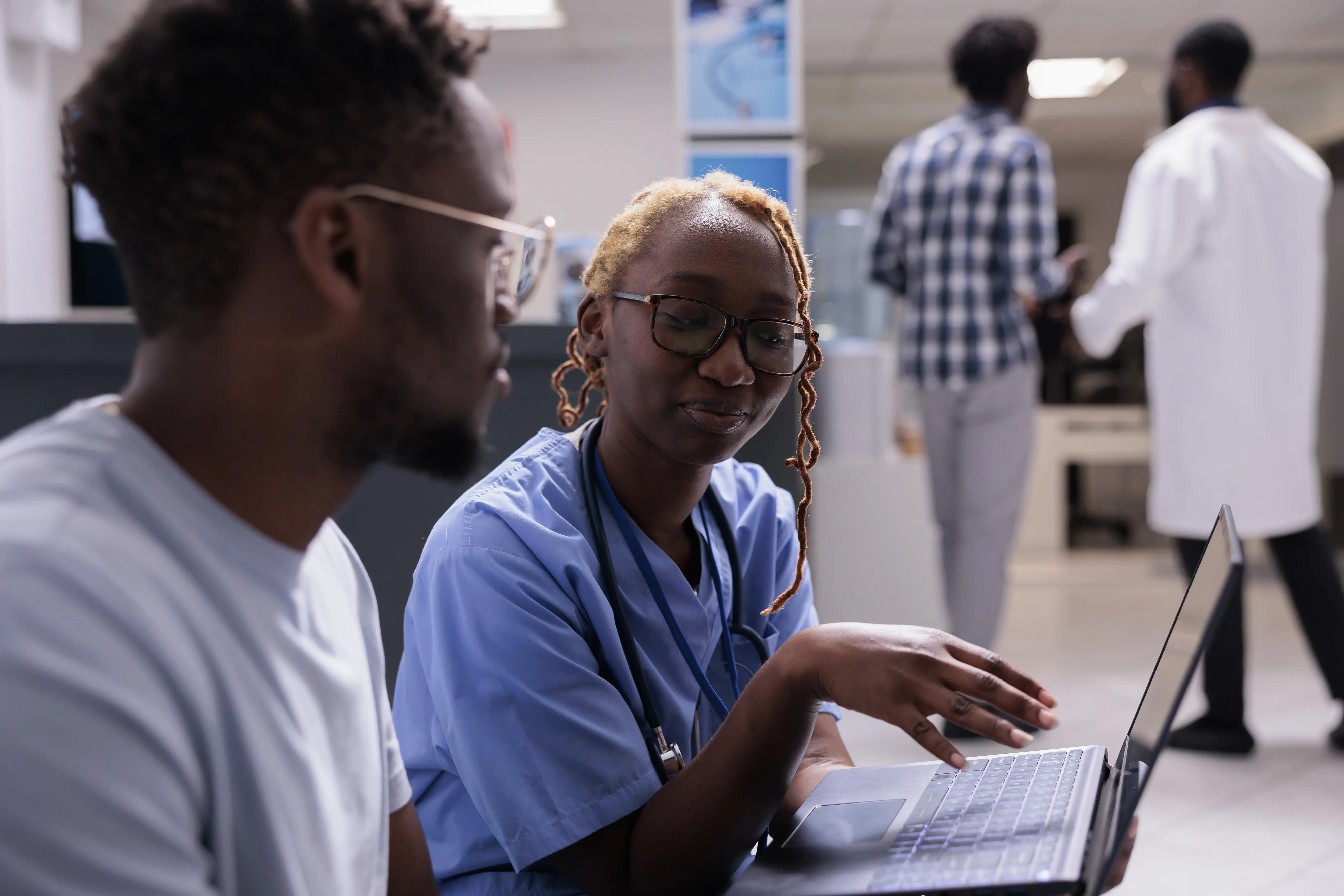 Nurse assisting a patient with medical information on a laptop